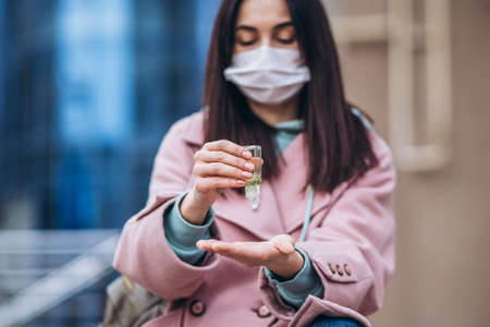 Female in medical mask outdoors in the empty city. Health protection and prevention of virus outbreak, coronavirus, COVID-19, epidemic, pandemic, infectious diseases, quarantine conceptの写真素材