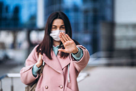 Female in medical mask outdoors in the empty city. Health protection and prevention of virus outbreak, coronavirus, COVID-19, epidemic, pandemic, infectious diseases, quarantine conceptの写真素材