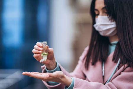 Female in medical mask outdoors in the empty city. Health protection and prevention of virus outbreak, coronavirus, COVID-19, epidemic, pandemic, infectious diseases, quarantine conceptの写真素材