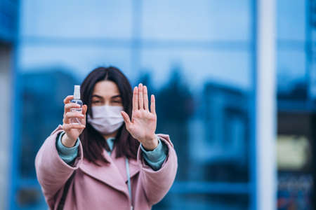 Female in medical mask outdoors in the empty city. Health protection and prevention of virus outbreak, coronavirus, COVID-19, epidemic, pandemic, infectious diseases, quarantine conceptの写真素材