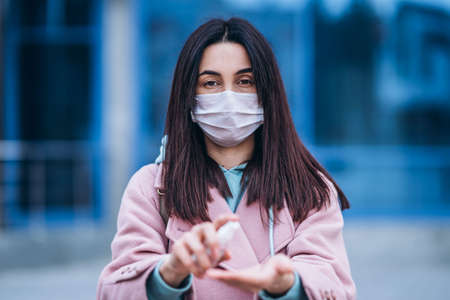 Female in medical mask outdoors in the empty city. Health protection and prevention of virus outbreak, coronavirus, COVID-19, epidemic, pandemic, infectious diseases, quarantine conceptの写真素材