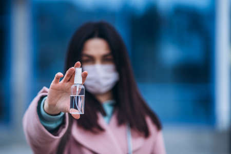 Female in medical mask outdoors in the empty city. Health protection and prevention of virus outbreak, coronavirus, COVID-19, epidemic, pandemic, infectious diseases, quarantine conceptの写真素材