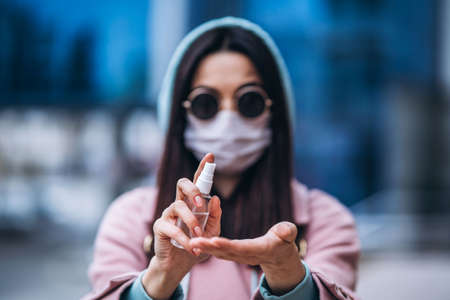 Female in medical mask outdoors in the empty city. Health protection and prevention of virus outbreak, coronavirus, COVID-19, epidemic, pandemic, infectious diseases, quarantine conceptの写真素材