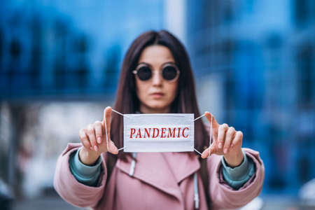 Female in medical mask outdoors in the empty city. Health protection and prevention of virus outbreak, coronavirus, COVID-19, epidemic, pandemic, infectious diseases, quarantine conceptの写真素材
