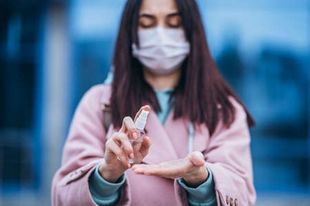 Female in medical mask outdoors in the empty city. Health protection and prevention of virus outbreak, coronavirus, COVID-19, epidemic, pandemic, infectious diseases, quarantine conceptの写真素材