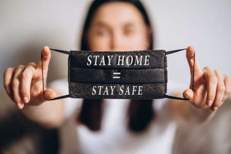 Female at home in quarantine time holding colorful protective medical masks to prevent virus disease, COVID-19, pandemic, epidemic conceptの写真素材