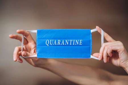 Female at home in quarantine time holding colorful protective medical masks to prevent virus disease, COVID-19, pandemic, epidemic conceptの写真素材