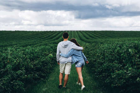Young couple with backpacks on their backs smiling and walking in the forest, enjoy the walk.の写真素材