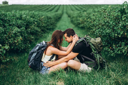 Young couple with backpacks on their backs smiling and walking in the forest, enjoy the walk.の写真素材