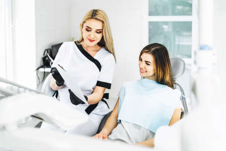 Dentist showing x-ray for the patient and explaining plan of treatmentの写真素材