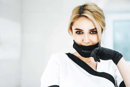 Pertrait photo of the female doctor in black mask and black glovesの写真素材