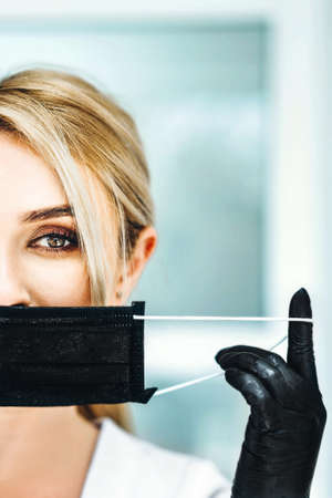 Pertrait photo of the female doctor in black mask and black glovesの写真素材
