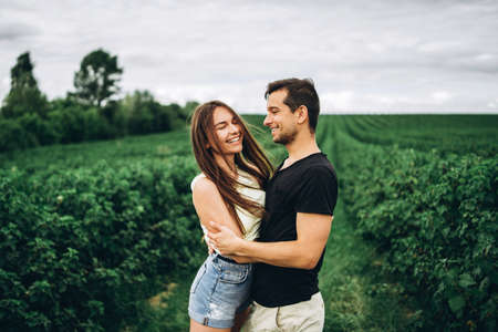 A tender loving couple walking in a field of currant. Man whirls woman in her arms. Love story.の写真素材