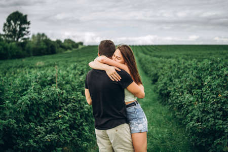A tender loving couple walking in a field of currant. Man whirls woman in her arms. Love story.の写真素材