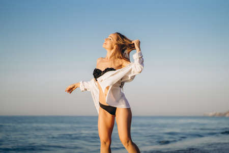 Pretty brunette woman relaxing on the beach at the seaの写真素材