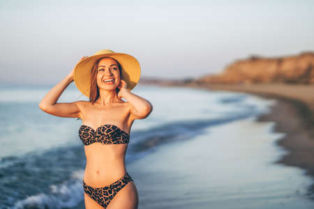 Pretty brunette woman relaxing on the beach at the seaの写真素材