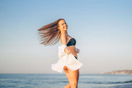 Pretty brunette woman relaxing on the beach at the seaの写真素材