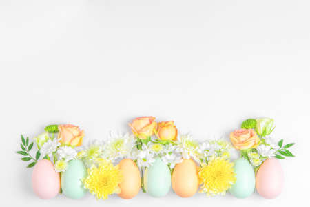 Creative layout composition of flowers and easter eggs on pastel backgroundの写真素材