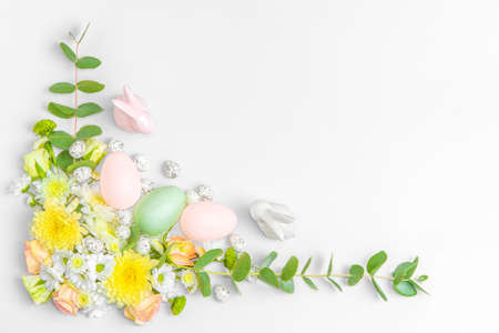 Creative layout composition of flowers and easter eggs on pastel backgroundの写真素材