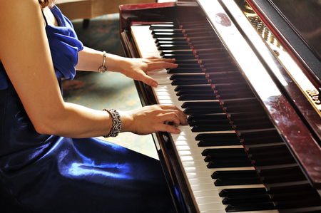 Women playing the grand piano in the roomの写真素材