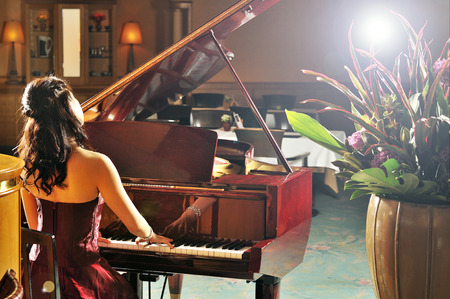 Women playing the grand piano in the roomの写真素材