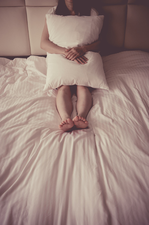 asian girl sitting on the bedの写真素材