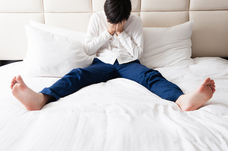 Men suffering on the bedの写真素材