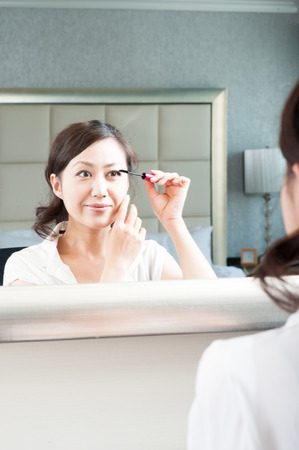 Women who have a makeup to look in the mirrorの写真素材