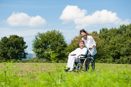 Senior riding in a wheelchair in the parkの写真素材