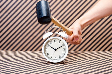 Break the alarm clock with a hammerの写真素材