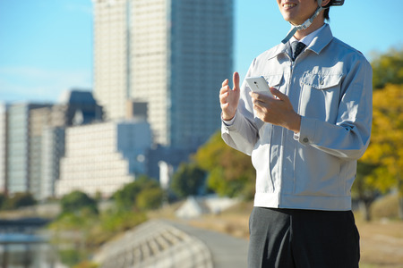 Men to work under the blue sky, smart phoneの写真素材