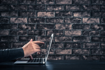 Man working on laptop in dark room