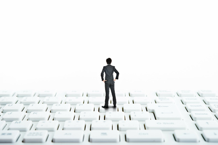 Businessman standing on top of the computer keyboardの写真素材