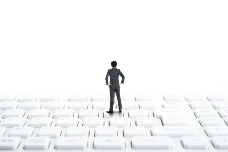 Businessman standing on top of the computer keyboardの写真素材