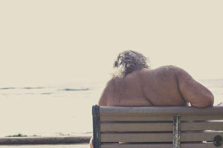 Large man sitting on a benchの写真素材
