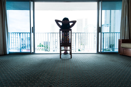 Women look out from the window of the roomの写真素材