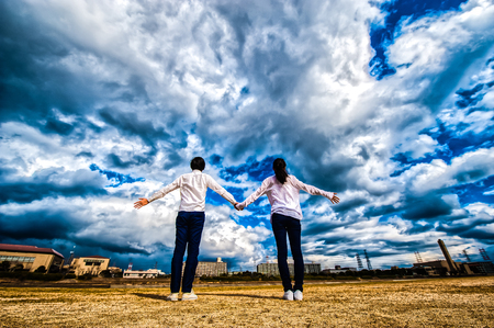 Men and women raise their hands toward the skyの写真素材
