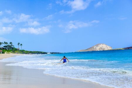 Woman to stand up to the big waveの写真素材