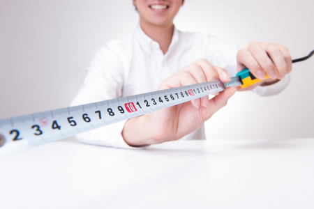 Men measure the length with a rulerの写真素材