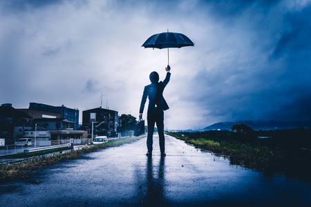 businessman are holding an umbrella, dark imageの写真素材