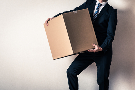 Businessman carrying a cardboard boxの写真素材