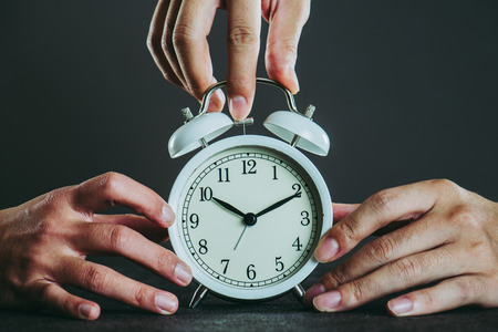 Alarm clock and lots of human handsの写真素材