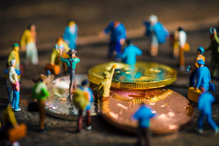 Miniature people with bit coinの写真素材