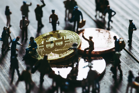 Miniature people with bit coinの写真素材