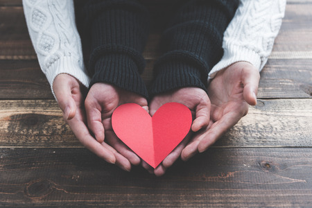 Male and female couple have a red heart on the wood tableの写真素材