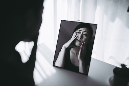 woman who is shocked by seeing a mirrorの写真素材
