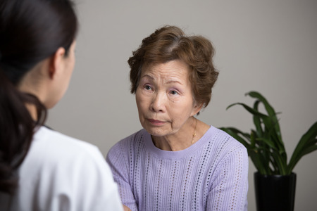 Asian elderly women talking to a doctorの写真素材