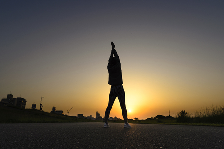 woman warming up with the morning sunの写真素材