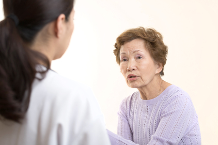 Asian elderly women talking to a doctorの写真素材