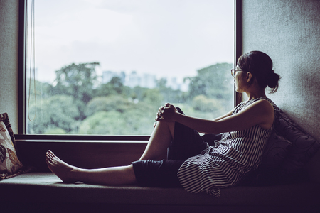 woman looking at a windowの写真素材